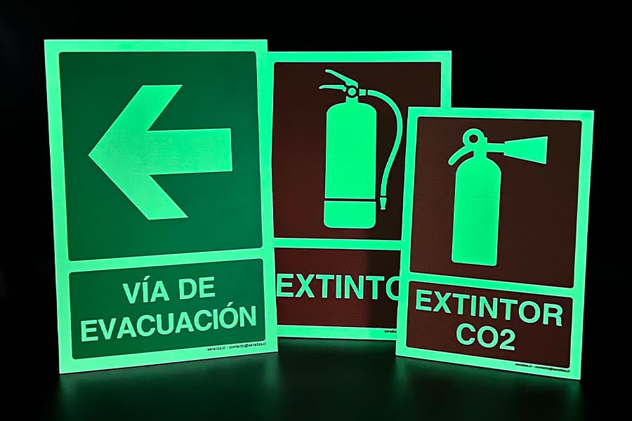 Set de señales fotoluminiscentes de vía de evacuación y extintor, brillando en la oscuridad